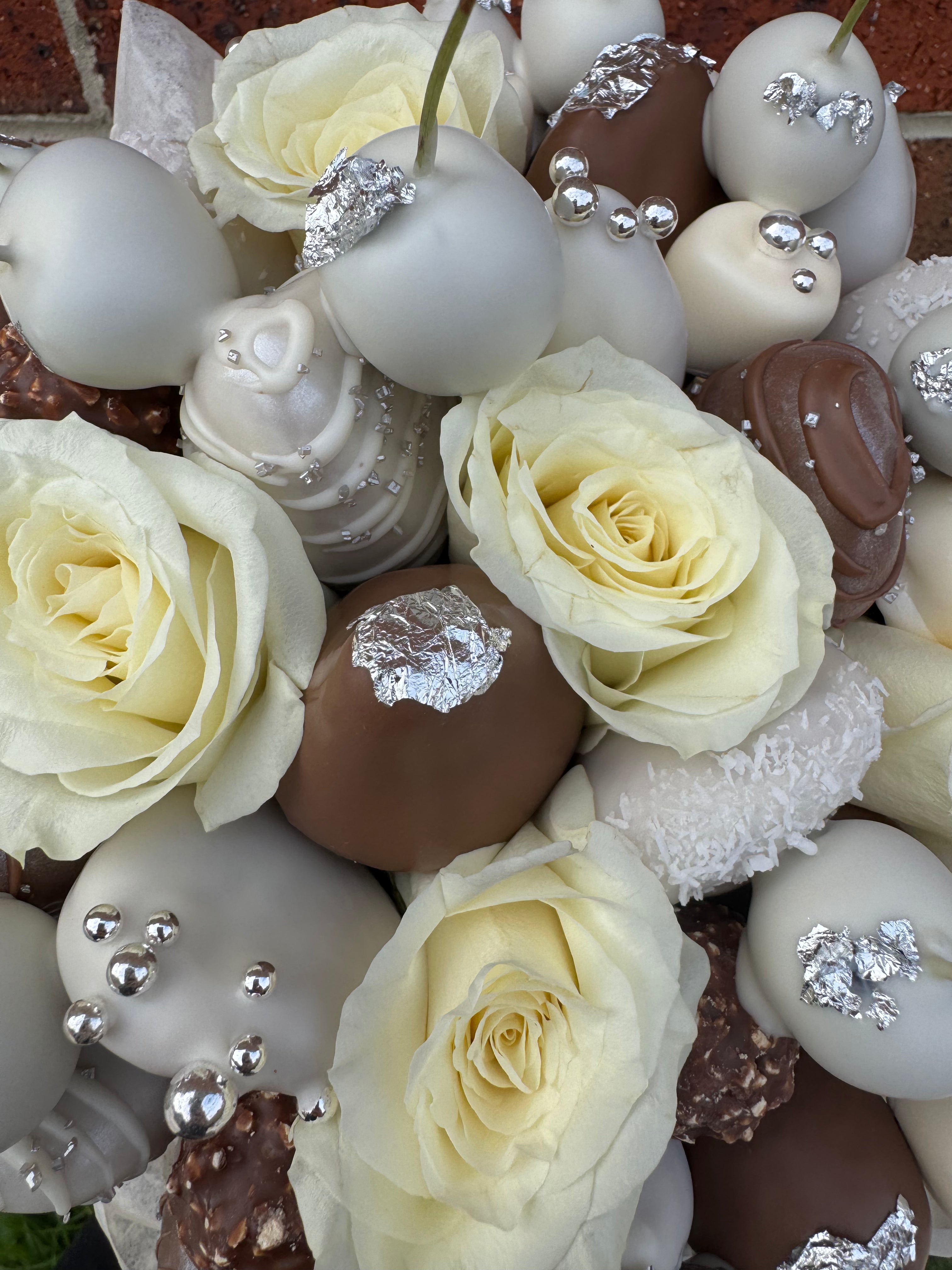 Close-up of chocolate-dipped strawberries decorated in silver and diamond tones