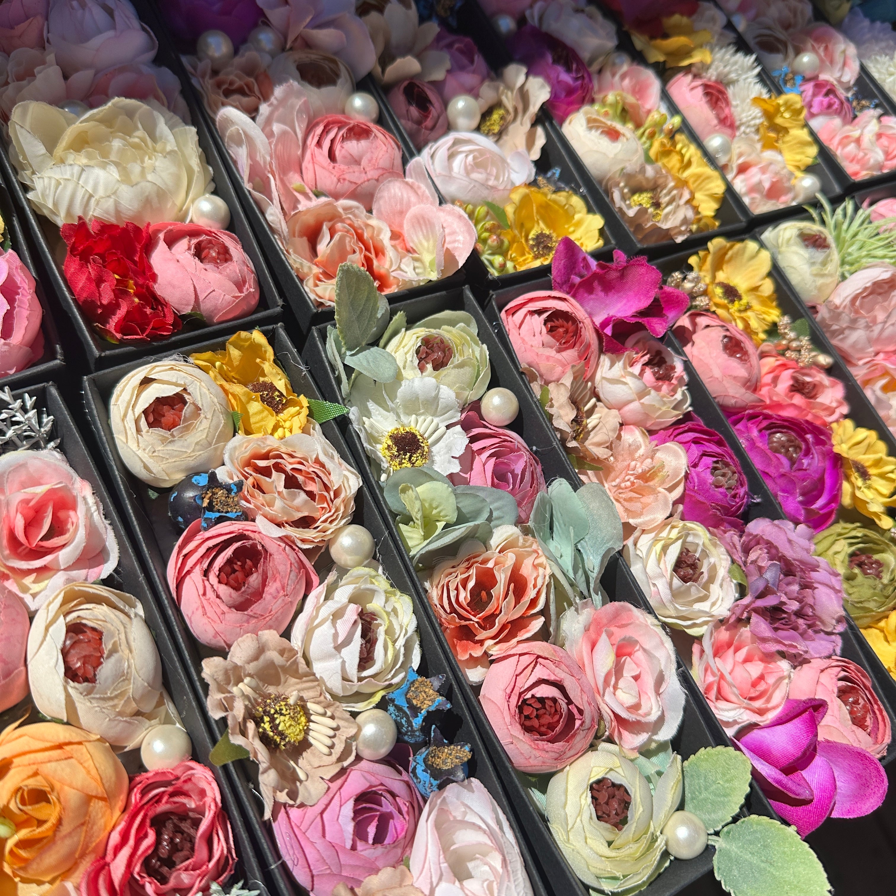 Artificial silk flowers arranged in a petite keepsake gift box
