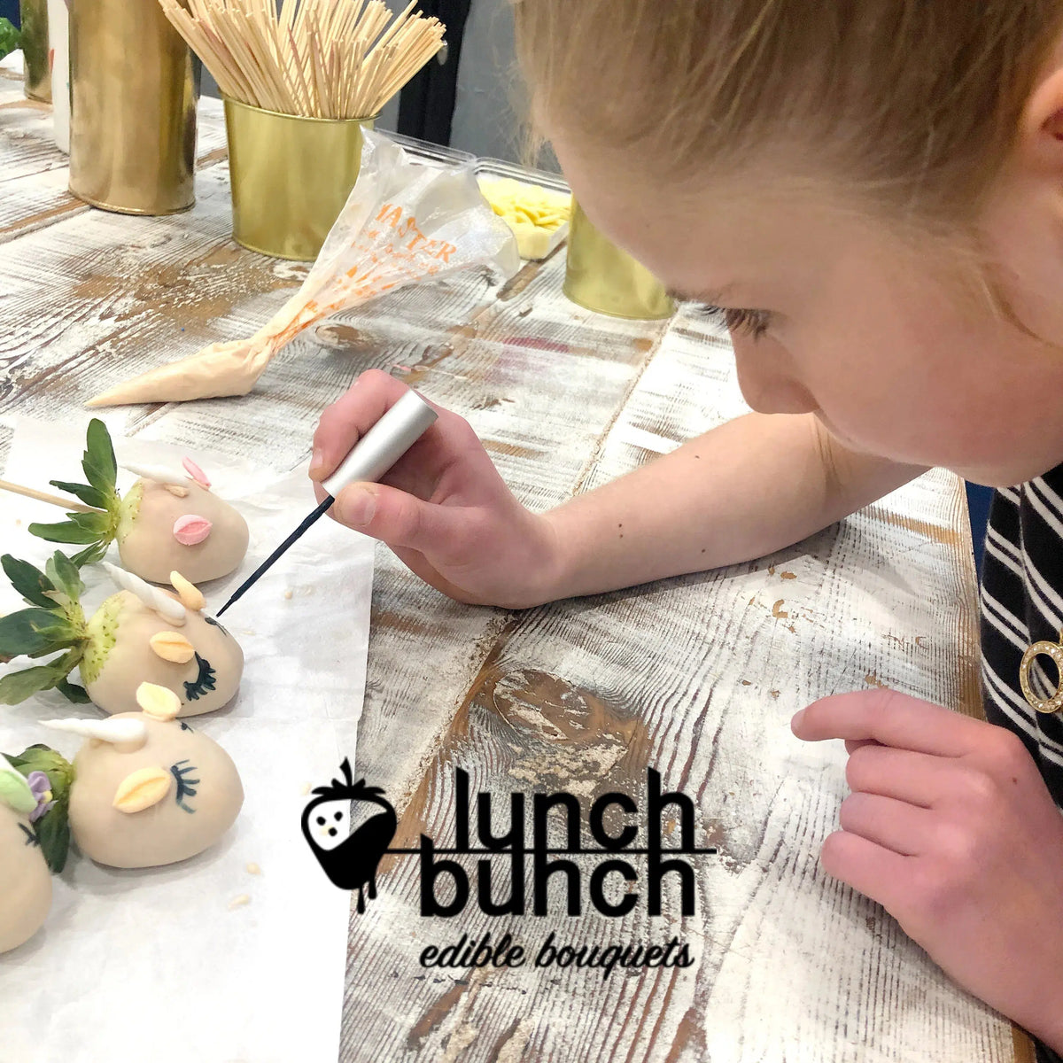 Child decorating chocolate strawberries during a Lunch Bunch kids chocolate workshop in Camberwell, Melbourne