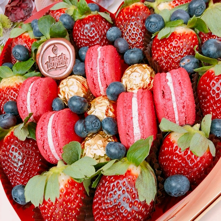 Romantic gift with fresh strawberries and macaroons in love heart arrangement