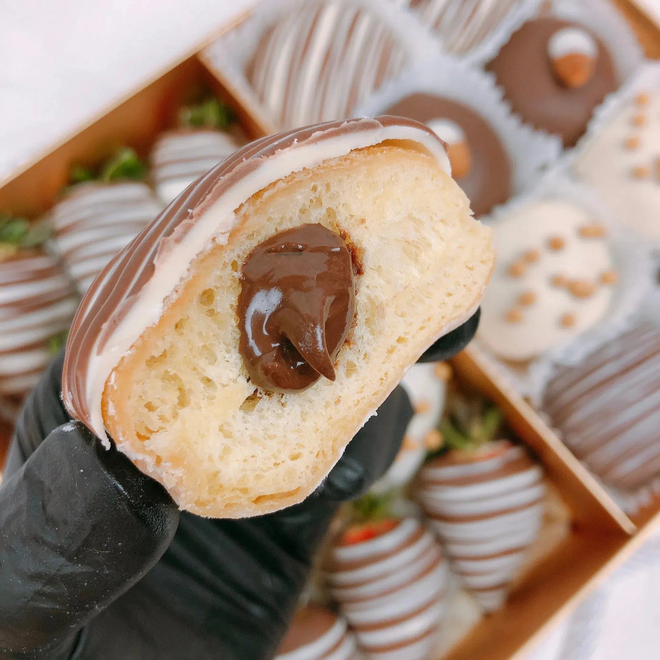 Chocolate decorated doughnuts and strawberries in a hamper box