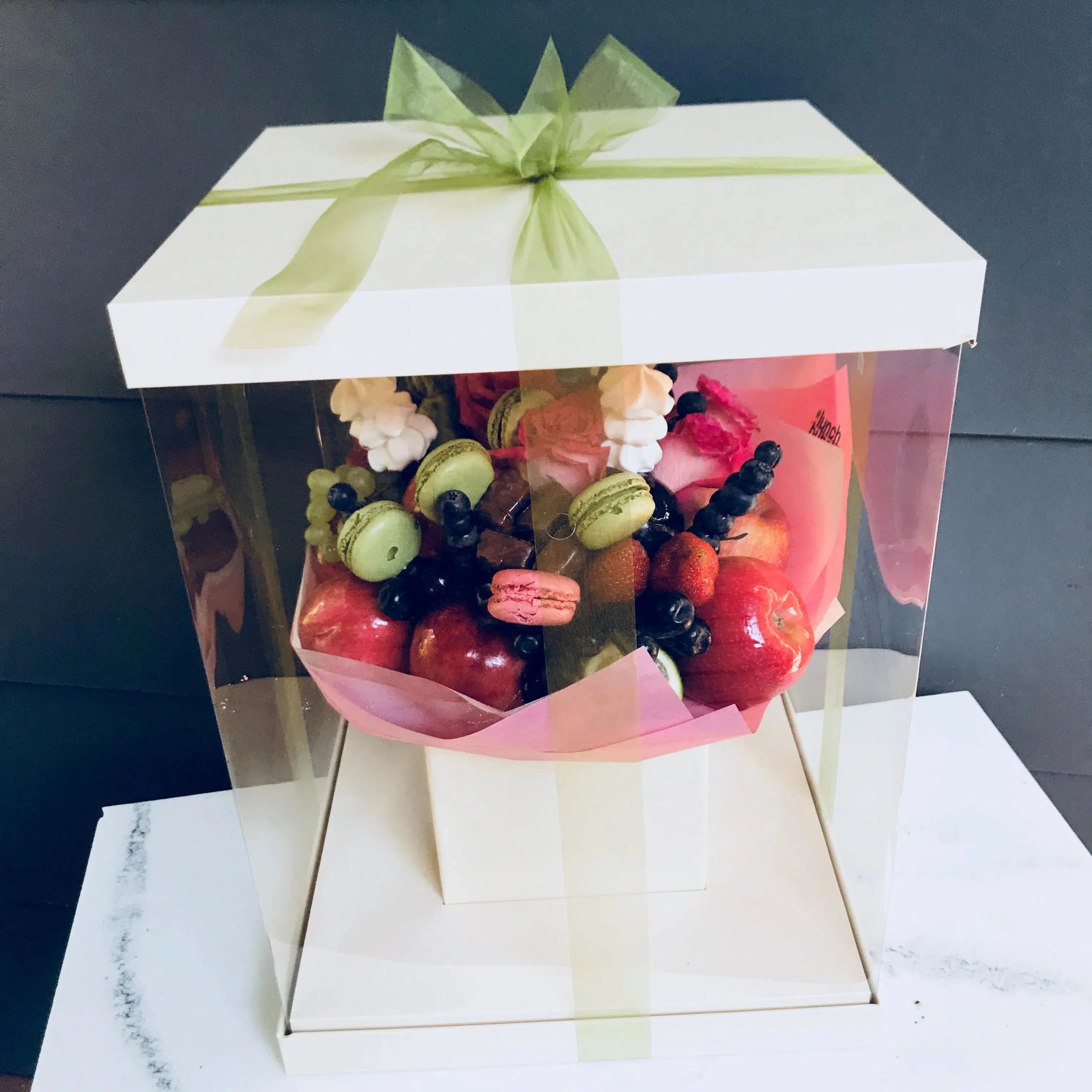 Fruit, berries and flowers bouquet filled with macarons 