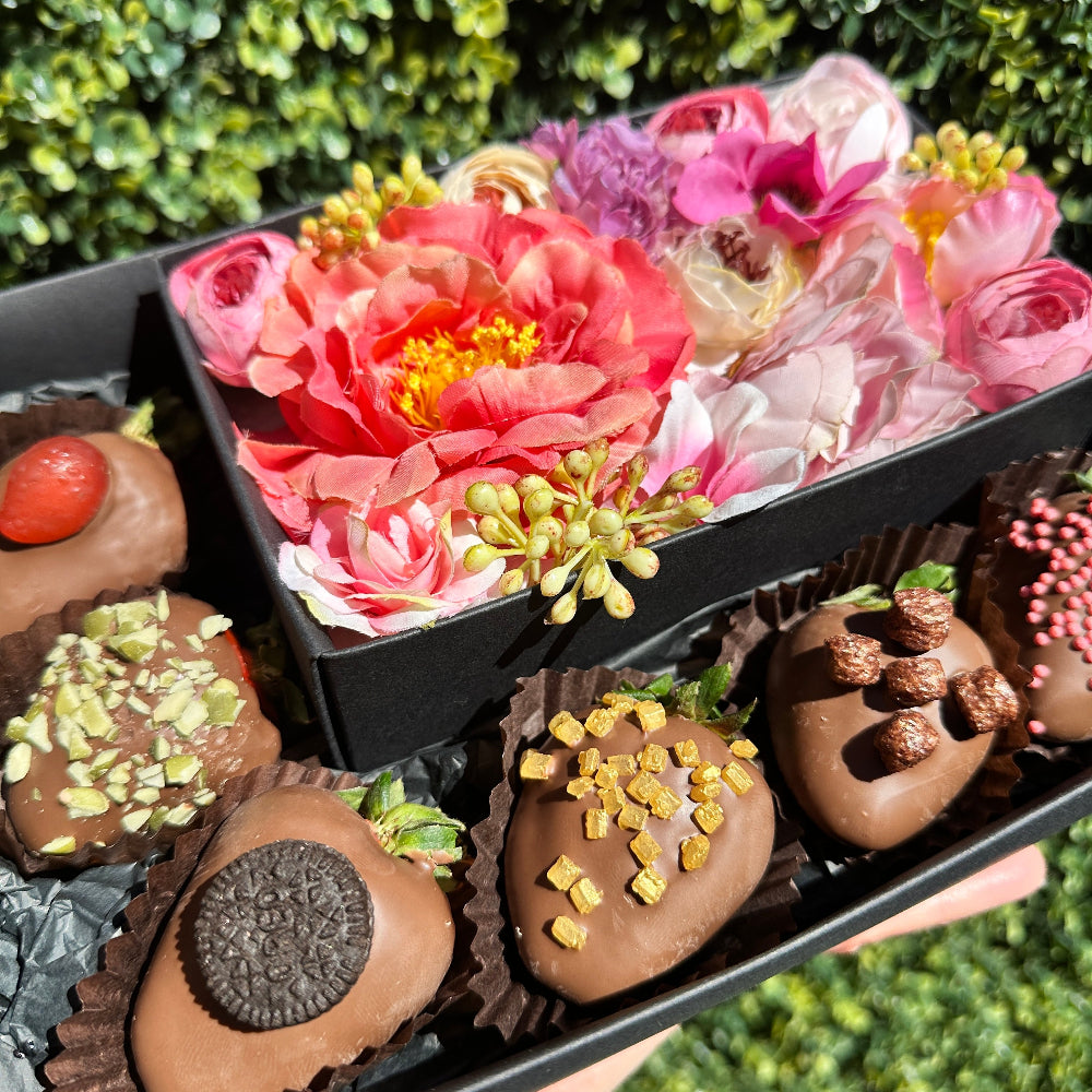 Assorted chocolate strawberries in a gift box with silk flowers