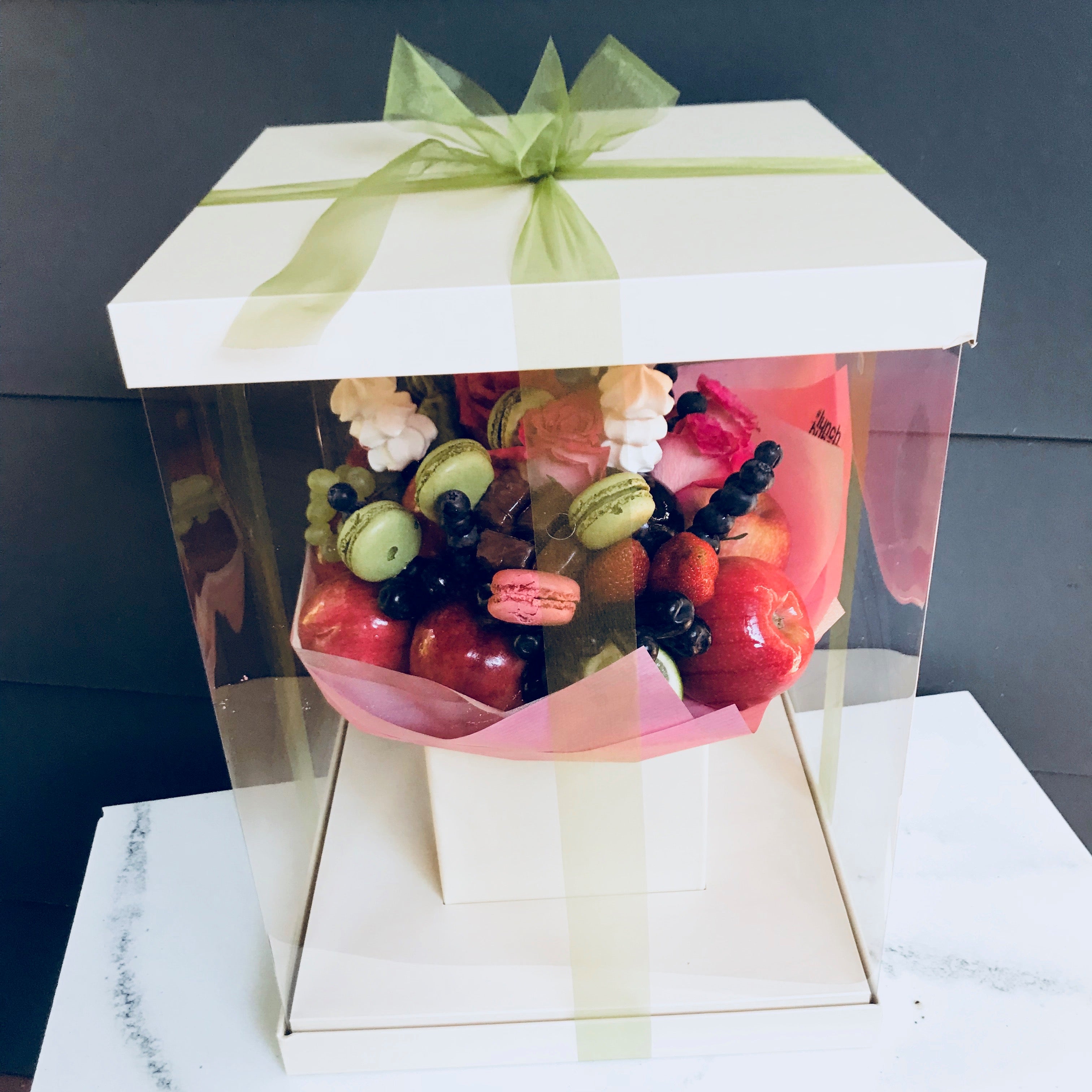 Fruit, berries and flowers bouquet filled with macarons 